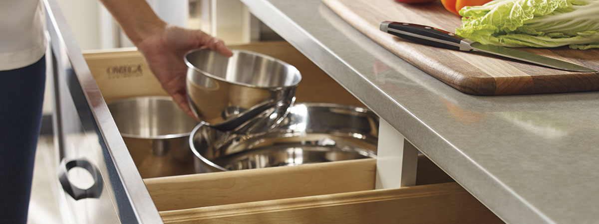 Woman pulling a bowl out of an Omega cabinet drawer